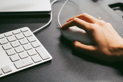 Close-up of a hand on a computer mouse beside a numeric keypad
