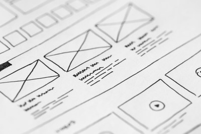 Hand-drawn wireframe sketch with placeholder image boxes and content lines, representing storyboarding